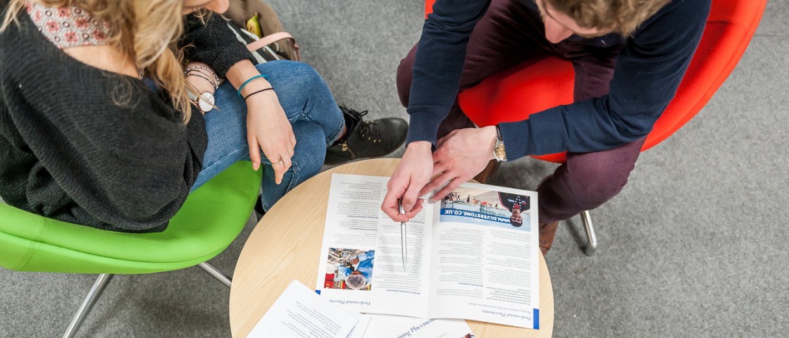 Careers adviser and student sitting at a table.