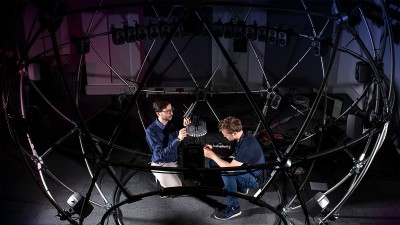 Two men adjusting the sound sphere facility equipment