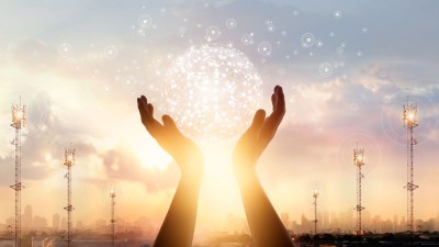 Hands holding up a bubble with the sun setting in the background