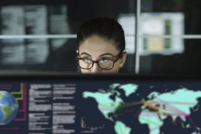 Woman looking at a computer screen with map of the world