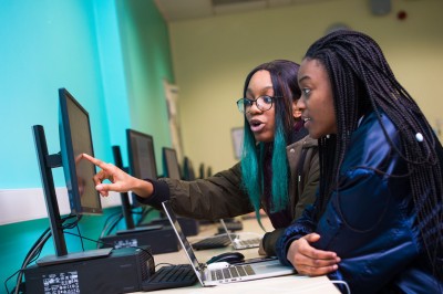 Two female computer science students discuss their work