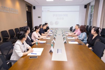 President of University of Surrey's China Alumni Association Mr Wu Ning's visit to SII-DUFE with group sitting around a board table