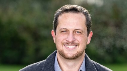 head and shoulders of PAI's Dr Erick Sperandio, smiling, trees in background