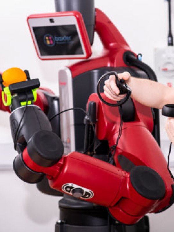 Student wearing virtual reality headset working with a robot