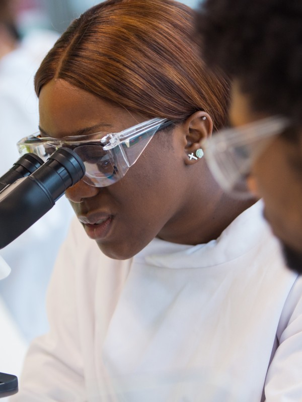 Female student looking through microscope