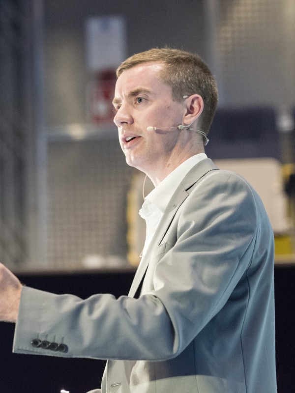 Dr Gardner stands on a podium addressing an audience