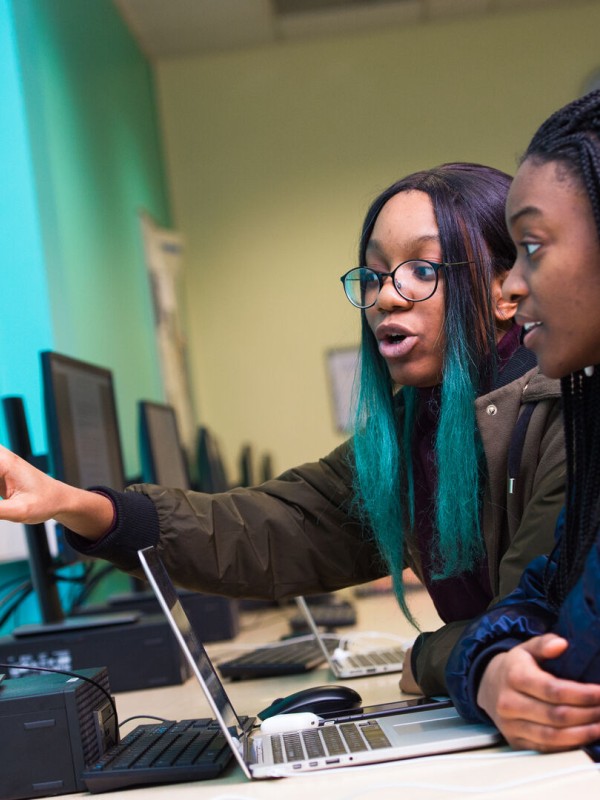 Two female computer science students discuss their work