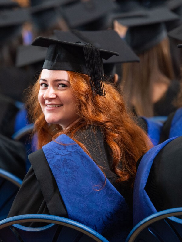 Surrey graduand turning around in graduation ceremony audience