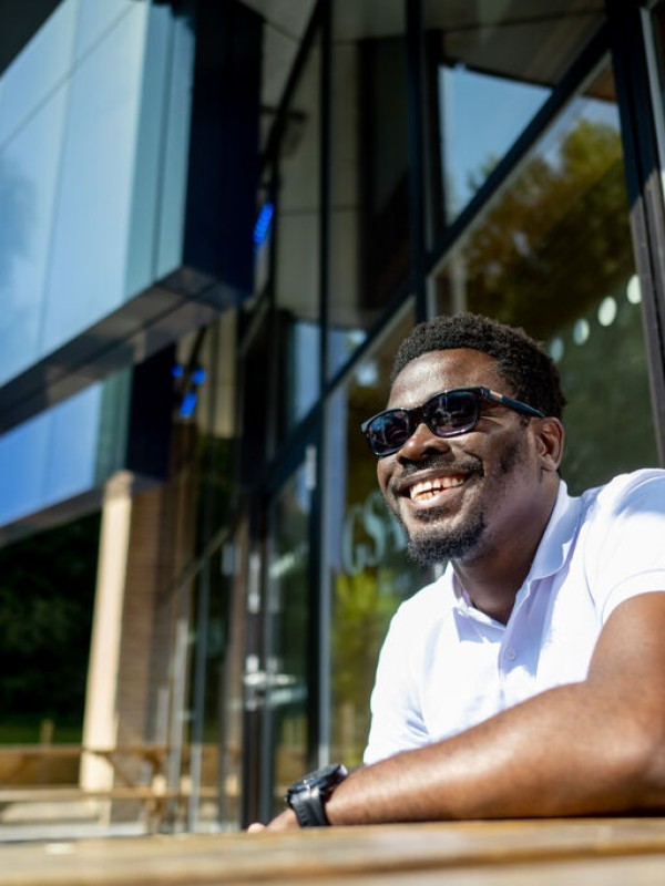 A student outside on campus in the sun