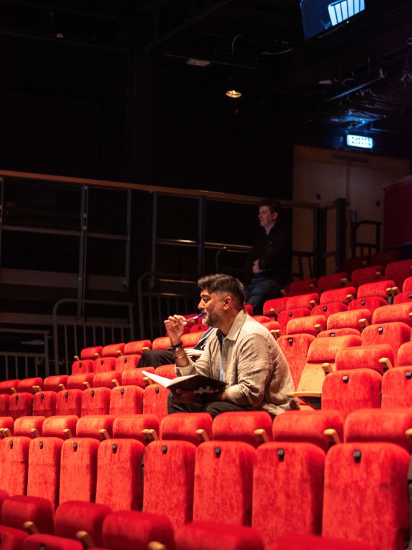 Ameer Choudrie directing in a theatre