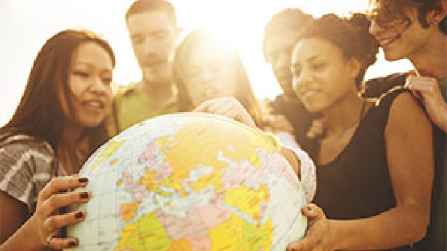 A group of people gathered around a globe
