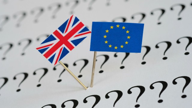 British and European flags sit on a page of question marks
