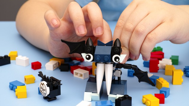A child is playing with Lego bricks.