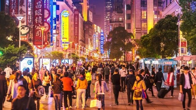 Crowds of people walking through city at night