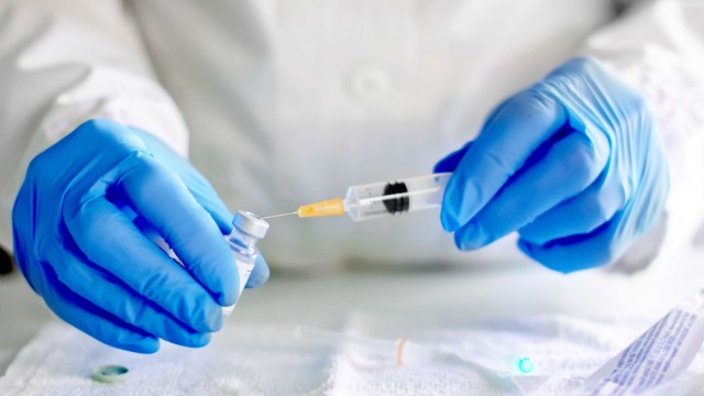 Scientist putting syringe in vile