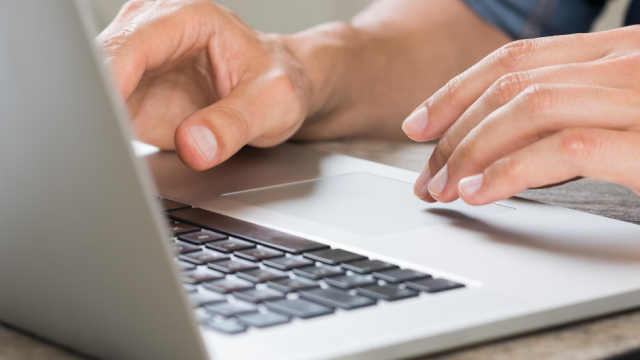 hands typing on a laptop keyboard 