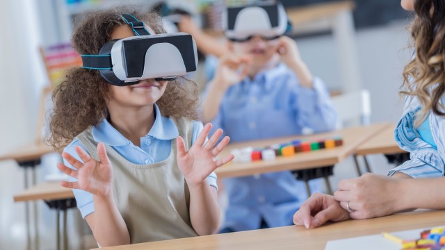 School children wearing virtual reality headsets