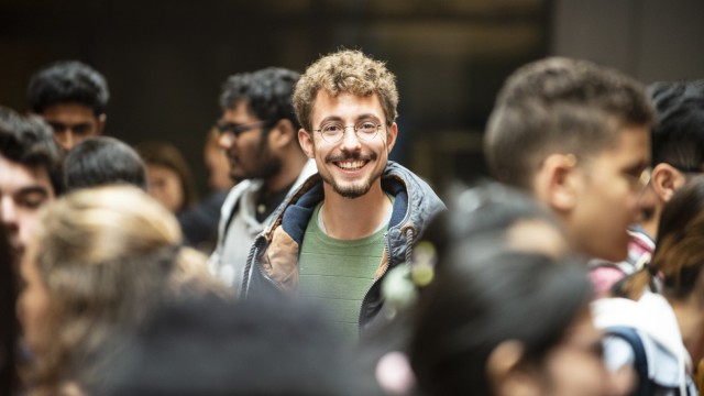 Student stands in a busy campus 