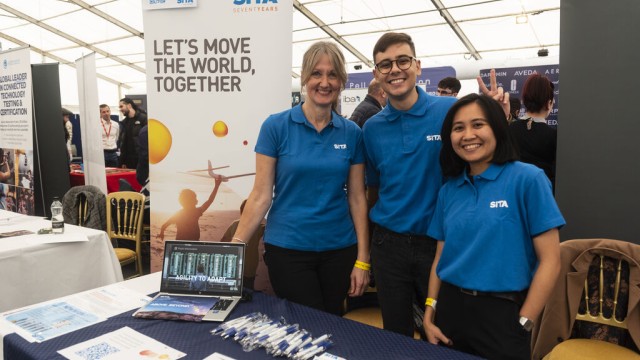 Students smiling in blue at careers fair