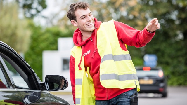 Staff member guiding cars
