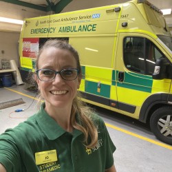 Jo takes a selfie in her paramedic uniform in front of an ambulance