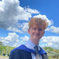 Photo of a ginger man in his graduation robes
