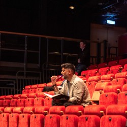 Ameer Choudrie directing in a theatre