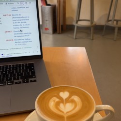 Cup of coffee with laptop in background