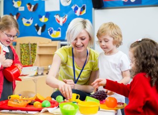 Children in a nursery with an adult teaching them