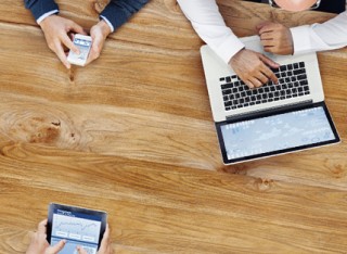 View from above of people using laptops, tablets and phones