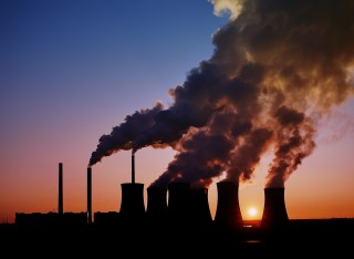 Power station with large amounts of smoke pouring from the top