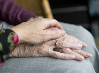 Carer holding hand of an elderly woman