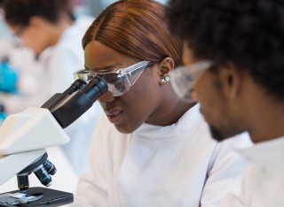 Female student looking through microscope