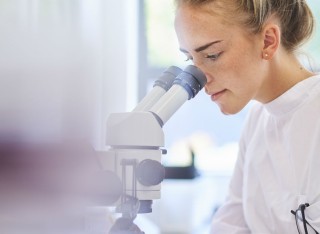 Student looking through a microscope
