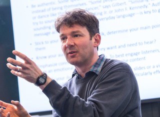 Dr Adrian Banks teaching in front of a whiteboard