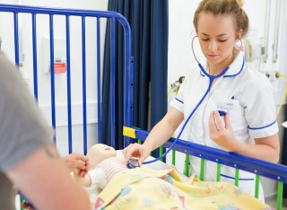 Student nurse checking heartbeat of child mannequin