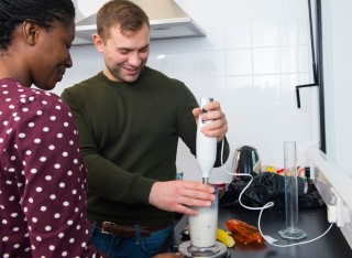 Student using a hand blender to make a smoothie