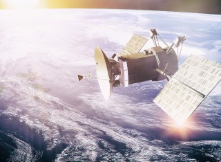 Image of a satellite in space, with the earth beneath it