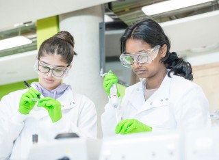 Two graduates doing medical sciences work in a laboratory setting