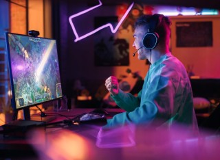 Male sitting in front of computer screen playing a video game