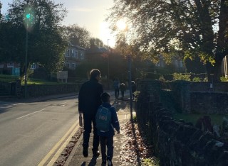 A grandfather and a grandson walking to school