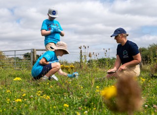 Children engaging in nature activities with an adult lead