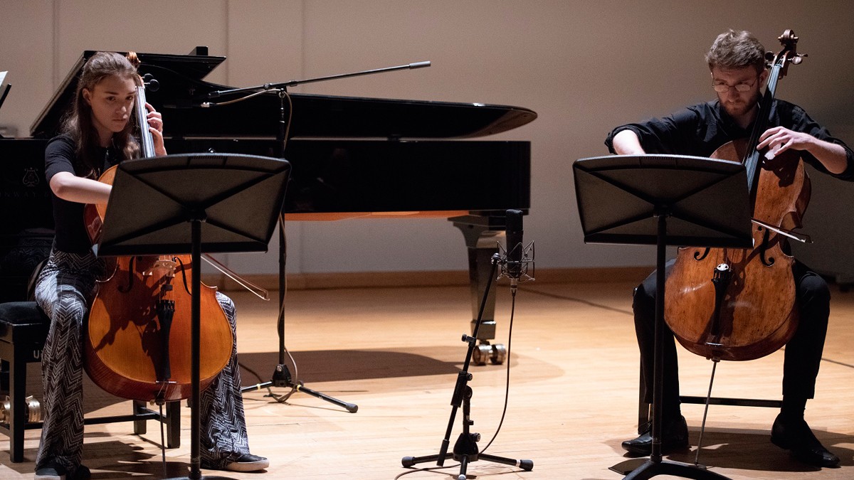 Male and female playing the cello