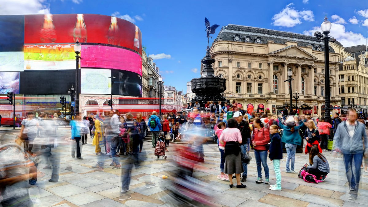 Lots of tourists walk around Piccadilly Circus in London