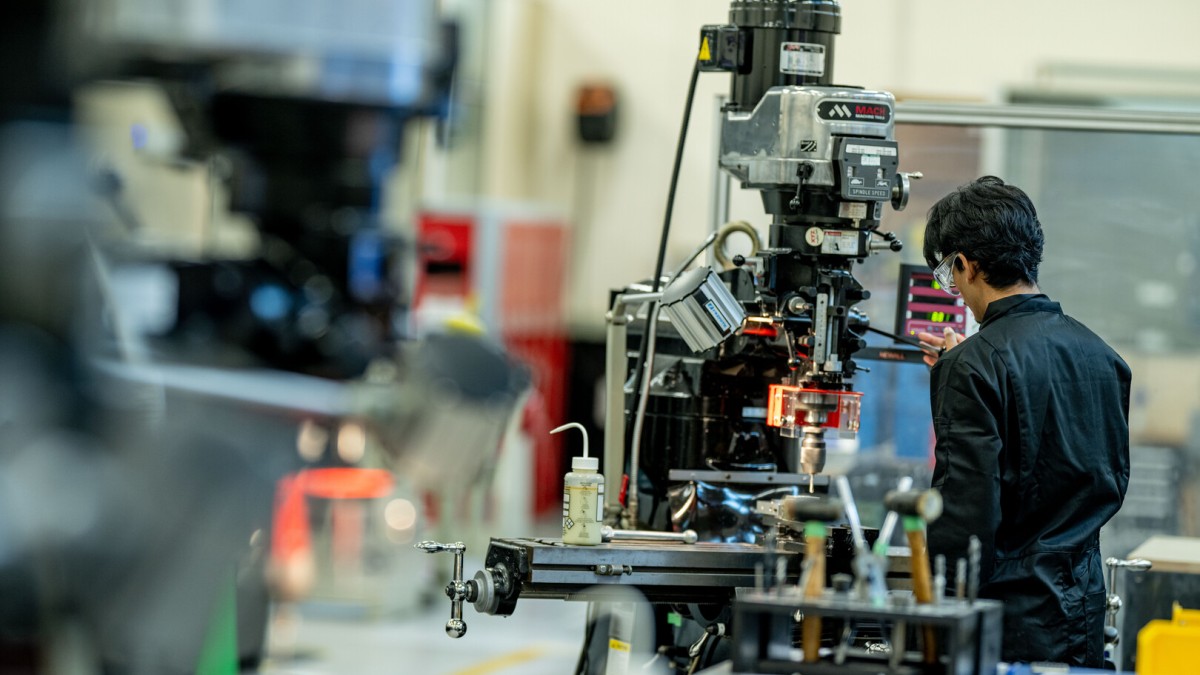 Student works on machines in engineering workshop