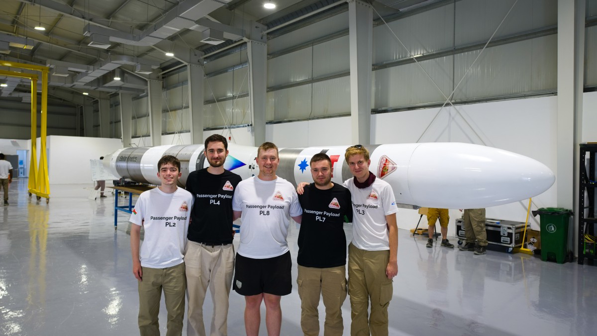 Students in Oman with a rocket behind them