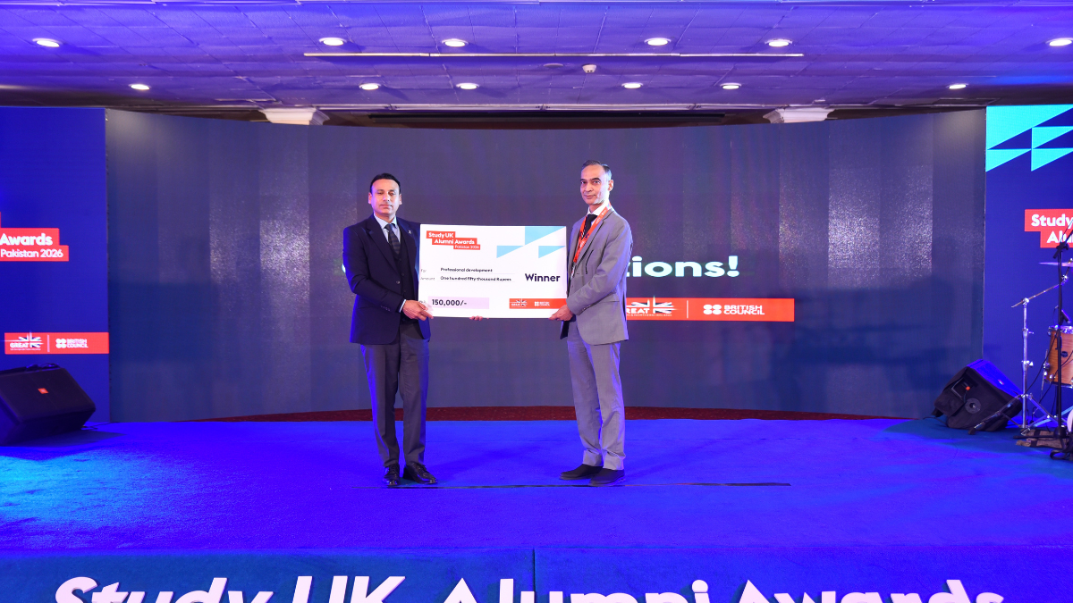 A photograph of alumnus Aon Bukhari accepting his award.