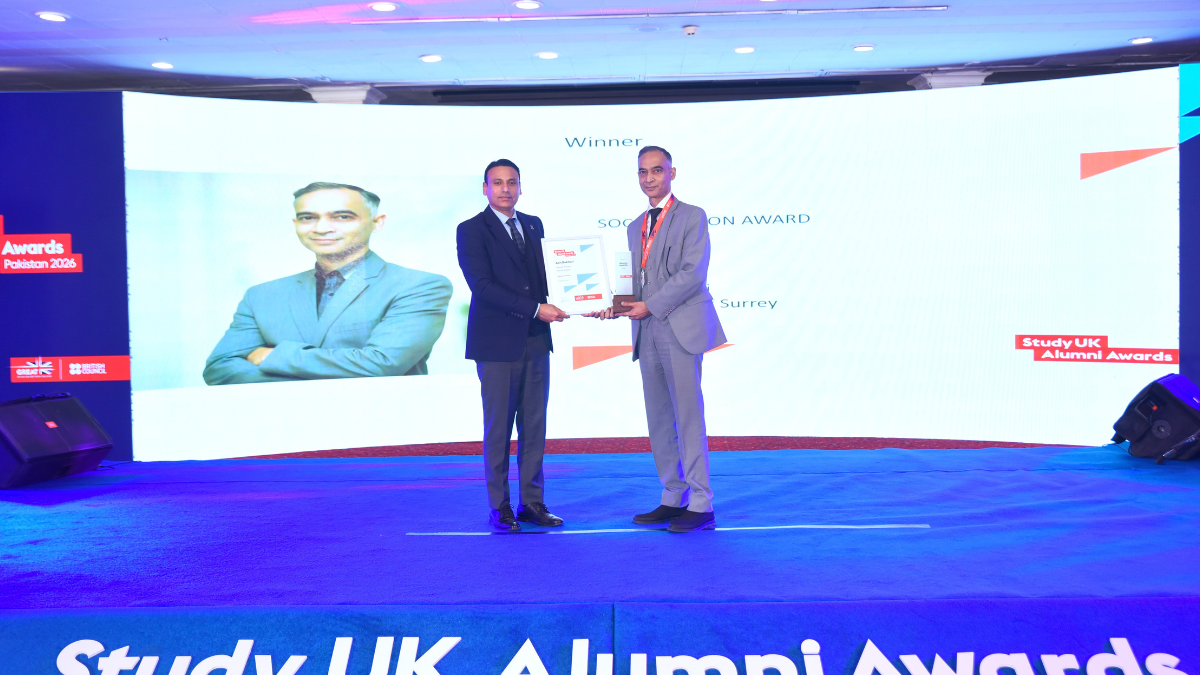 A photograph of alumnus Aon Bukhari accepting his award.