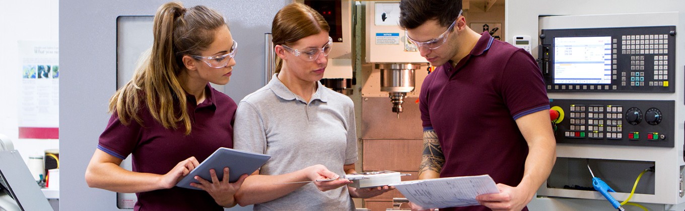 Students next to a CNC machine
