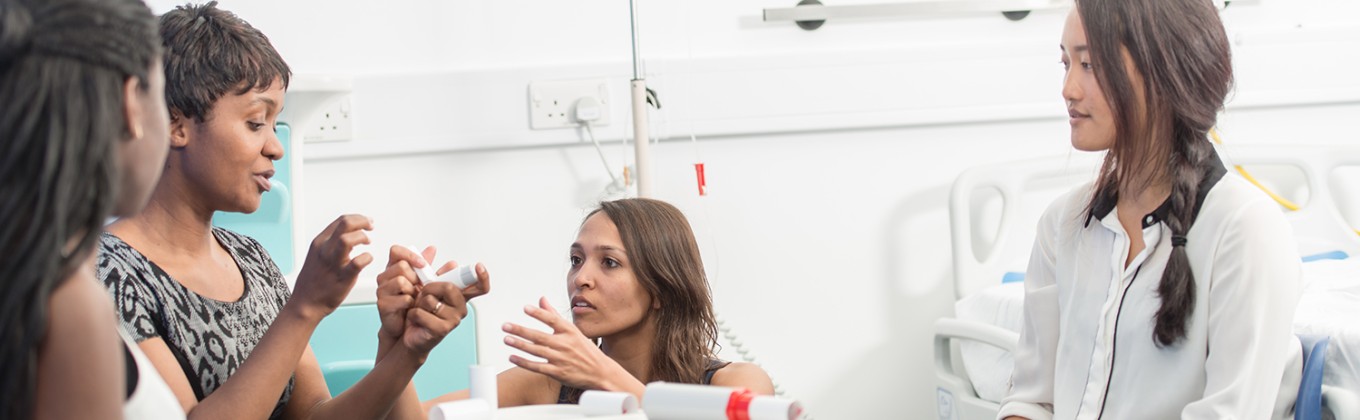 A a group of students discussing an asthma inhaler